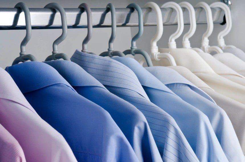 A row of shirts hanging on the rack.