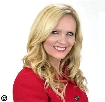 A woman in red jacket smiling for the camera.