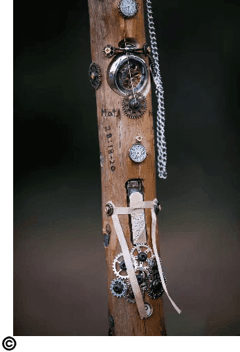 A wooden stick with various gears and chains on it.