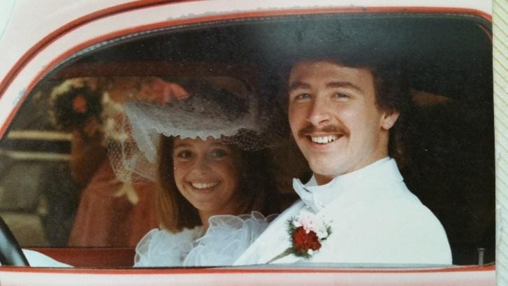 A man and woman in the back of a car.