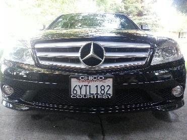 A black mercedes benz is parked in the driveway.